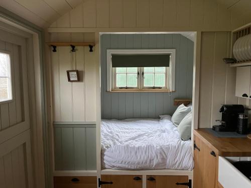 BurphamThe Deer Hut的一个小房间的一个床位,设有窗户