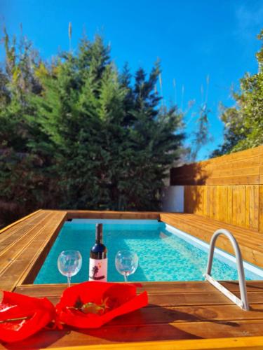 卡托克拉克阿纳Night Flower Villa的游泳池旁的桌子,上面有一瓶葡萄酒和玻璃杯