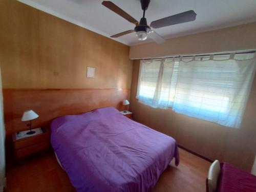 马德普拉塔Nuevo Hotel Tivoli的一间卧室配有紫色的床和吊扇