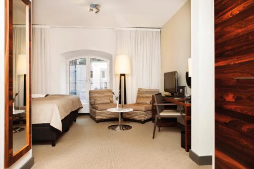 斯德哥尔摩Elite Hotel Marina Tower, Spa & Resort的酒店客房配有一张床、一把椅子和一张书桌
