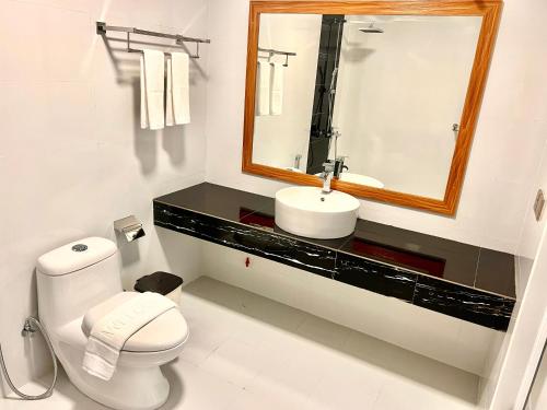 马米基里Vilu Residence的一间带水槽、卫生间和镜子的浴室