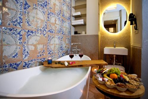 伊斯坦布尔Ayramin Exclusive Hotel - Special Category的浴室设有浴缸、一碗水果和酒杯