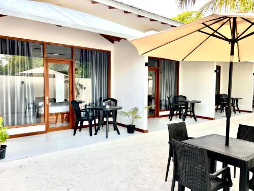 马米基里Vilu Residence的一个带桌椅和遮阳伞的庭院