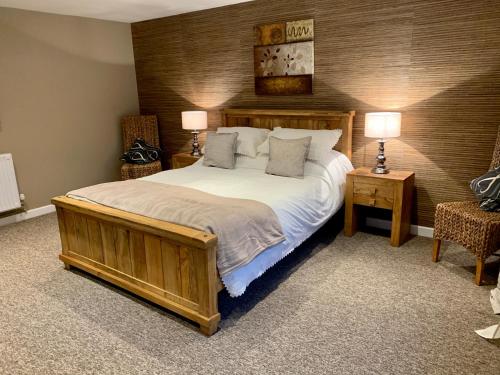 韦尔斯拱北农场住宿加早餐旅馆的一间卧室配有一张带两盏灯的大木床。