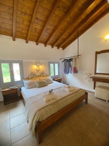 斯基亚索斯镇Calma Cottage的一间卧室设有一张带木制天花板的大床