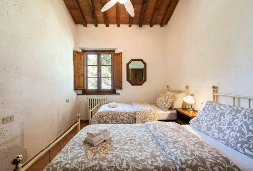 甘巴西泰尔梅Podere Boscone的一间卧室配有两张床和镜子