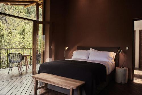 乌鲁班巴Andenia Boutique Hotel, Sacred Valley的一间卧室配有一张床,阳台配有桌子