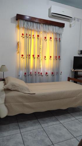 伊瓜苏港El Depto de la Abuela的一间卧室配有一张带窗帘的大床