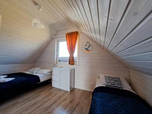 尼彻兹Comfortable holiday homes for 7 people, Niechorze的一间卧室设有两张床和窗户。