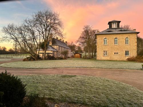 Saint-Germain-de-VarrevilleGîte du Haras de Vaugoubert的一座旧砖砌的建筑,上面有一座塔