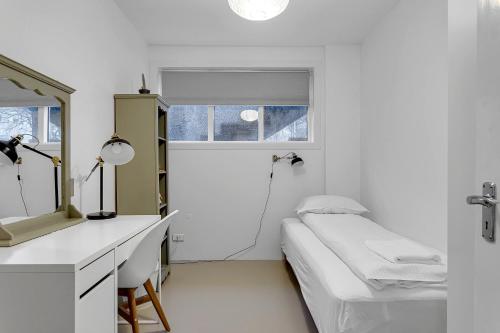 雷克雅未克Spacious and Central Apartment - 3 Bedrooms的白色的客房配有床和镜子