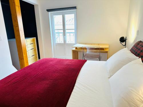 里斯本Castle cozy apartment的一间卧室配有一张带红白毯子的床