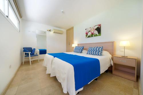 圣阿古斯丁卡塔利亚公寓的一间卧室配有蓝色和白色的床和蓝色枕头