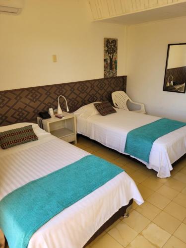 里奥阿查Hotel Gimaura的酒店客房设有两张床和一张桌子。