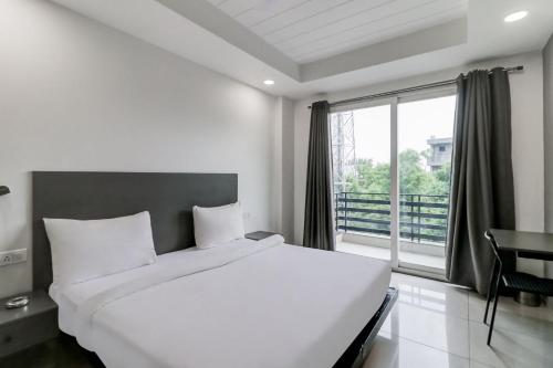 古尔冈RJK Stay - Sohna Road的卧室设有一张白色大床和一扇窗户。