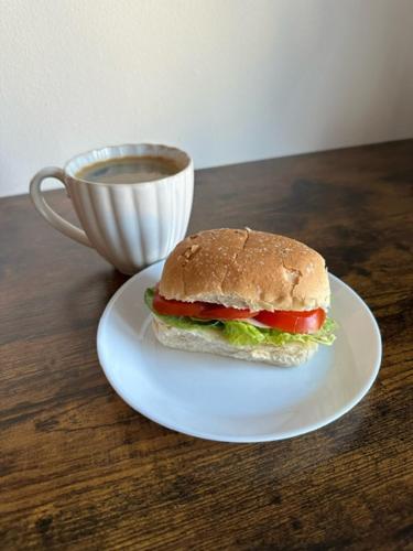 HärrydaLandvetter Airport B&B的咖啡旁盘子里的三明治