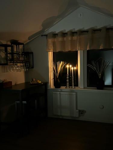 HärrydaLandvetter Airport B&B的一间设有窗户的暗室,配有桌子和蜡烛