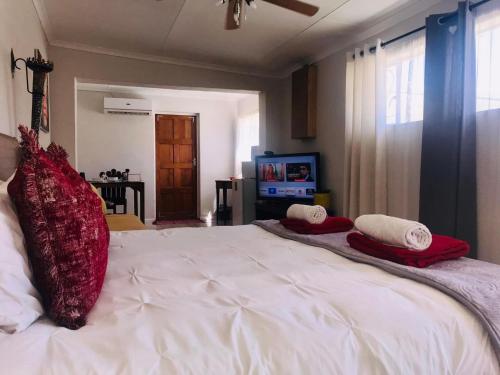格拉夫-里内特Toni's Cottage的卧室配有带红色枕头的大型白色床
