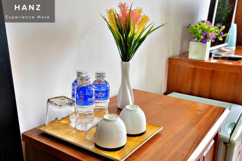 胡志明市HANZ Hotel Bui Vien upstair MP ChillBAR的一张带瓶子的木桌和花瓶