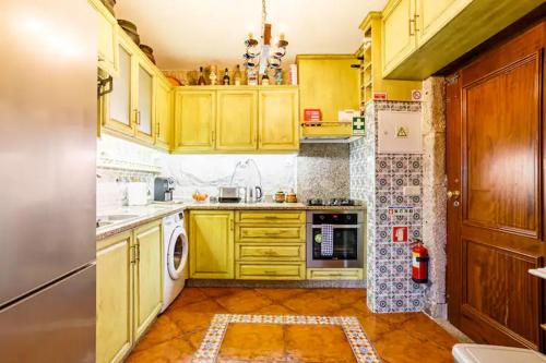 波尔图House CONTU1000的厨房配有黄色橱柜和炉灶烤箱