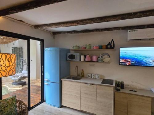 Gid‘onaמעיין הגלבוע的厨房配有蓝色冰箱和平面电视。