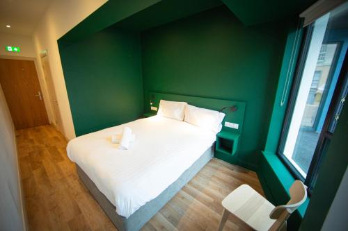 巴利纳Heyday Hostel Ballina的绿色墙壁间的一张床位