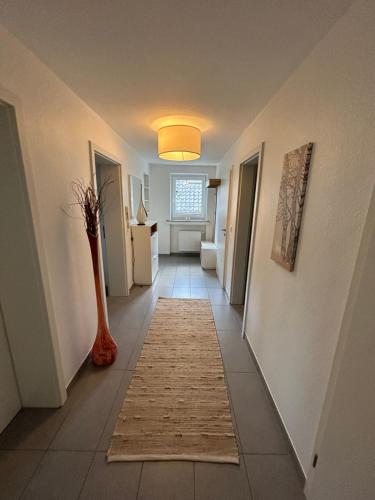 锡默拉特Kragemann Hotel & Vinothek的走廊上铺着地毯,铺着花瓶