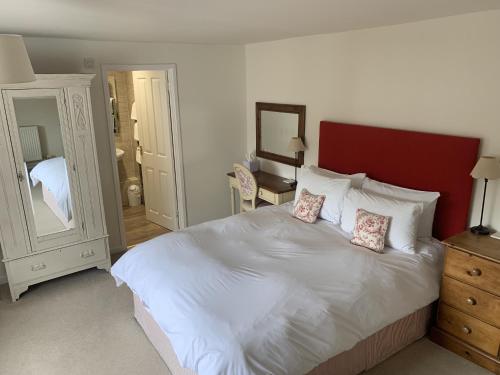 韦茅斯历史住宿加早餐旅馆的卧室配有一张带两个枕头的大白色床