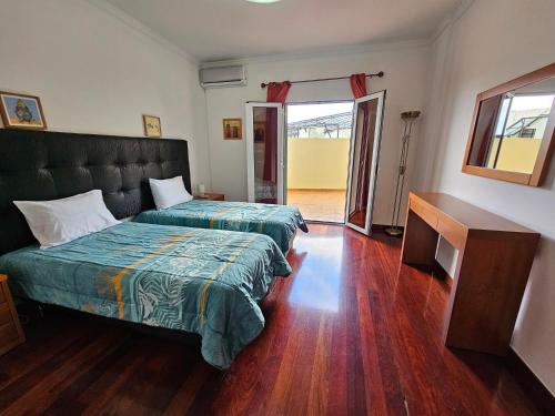 丰沙尔Apartment Bonimar的一间卧室配有两张床和电视。