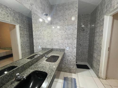 福塔莱萨Salve Maloca Hostel的浴室设有黑色水槽和2个水槽。