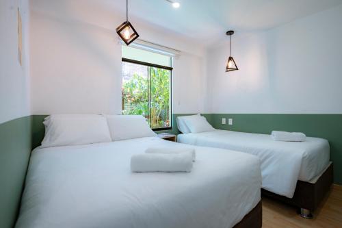 阿亚库乔Casa Samaykuy的带窗户的客房内的2张白色床