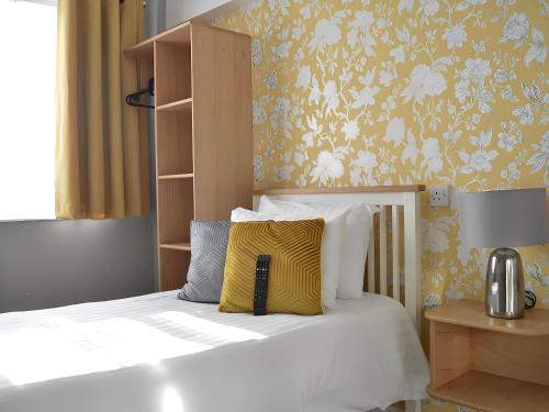 南安普敦明星酒店的一间卧室配有一张带黄色和白色枕头的床