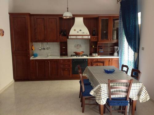 焦约萨马雷阿Giocasa的厨房配有木制橱柜和桌椅