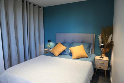 贝桑松*Hypercentre*Spacieux*Calme - Le Vauban - Cocoonhome的一间卧室配有一张带蓝色墙壁和黄色枕头的床