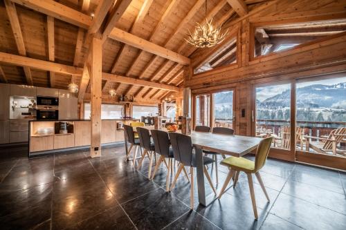 蒙特里永Chalet Heavenly Morzine - by EMERALD STAY的厨房以及带桌椅的用餐室。