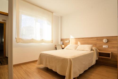 波多诺伏卡萨阿尔瓦利多旅馆的一间卧室设有一张大床和窗户