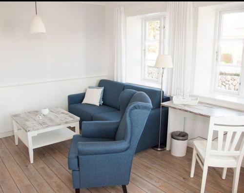 诺尔多夫Ual Öömrang Wiartshüs的客厅配有蓝色椅子和桌子