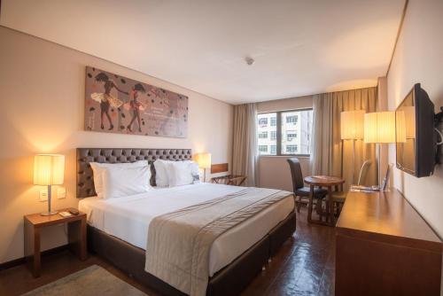 里约热内卢里约热内卢格雷别墅的酒店客房带一张床、一张桌子和椅子
