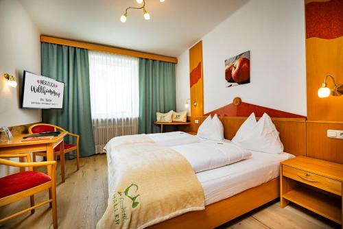 安格Der Thaller - Wirtshaus - Restaurant - Hotel的酒店客房设有一张大床和一张书桌。