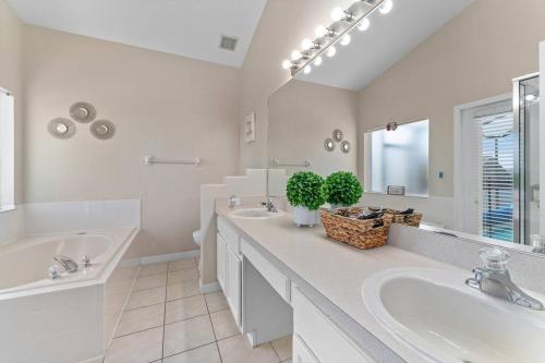 奥兰多Poolside Orlando Oasis的白色的浴室设有2个盥洗盆和1个浴缸。