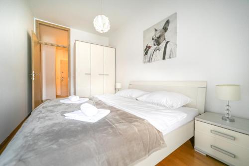 萨格勒布Trendy apartment 5 min to city centre!`的一间卧室配有一张带两条白色毛巾的床