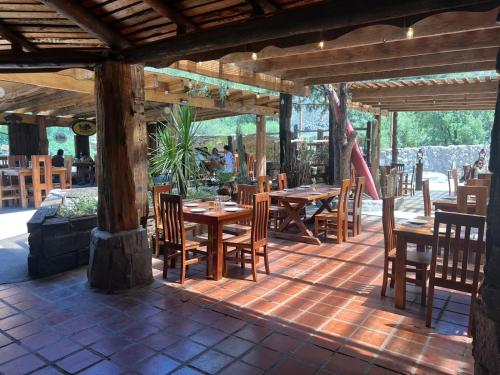MelocotónCabañas La Calchona的庭院中设有木桌椅的餐厅