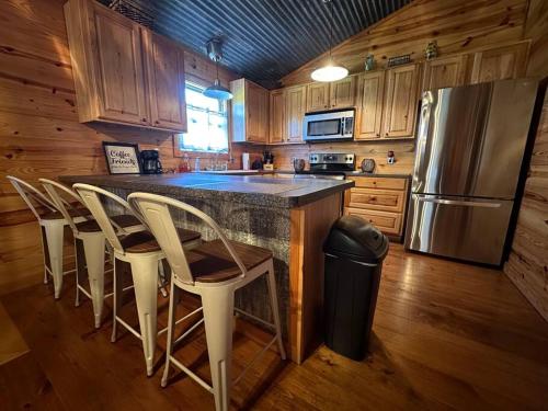 朗维尤Hillside Hideaway的厨房配有带椅子的柜台和冰箱。