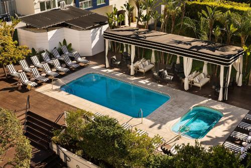 洛杉矶Sonder The Beacon的享有带椅子的游泳池和房屋的顶部景致