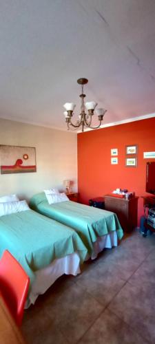 康考迪亚Habitación de huéspedes con entrada independiente的红色墙壁的酒店客房内的两张床