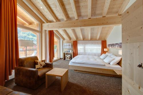 采尔马特阿里斯特拉瑞士弗莱尔酒店的一间卧室配有一张床和一把椅子