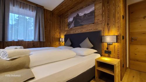 奥蒂塞伊Villa Dolomiti的卧室配有一张大白色床和窗户