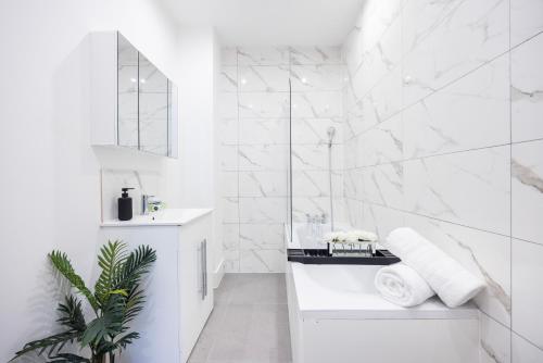 克罗伊登Brand New Modern Block of Apartments By AV Stays Short Lets London的白色的浴室设有水槽和镜子