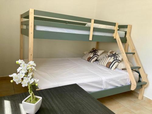哥西尔Logement Charme vanillé - Gosier - 2 chambres - Piscine - Wifi - Parking的一间带两张双层床的卧室和花瓶