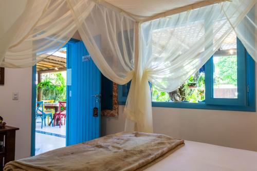 桑塔克鲁茨卡巴利亚Suite DAVI - Guest House Guaiu的一间卧室配有天蓬床和蓝色窗户